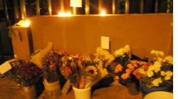 Candles burn and flowers are left outside the Corner House Pub in memory of  Richard Smyth and Christopher Patton.